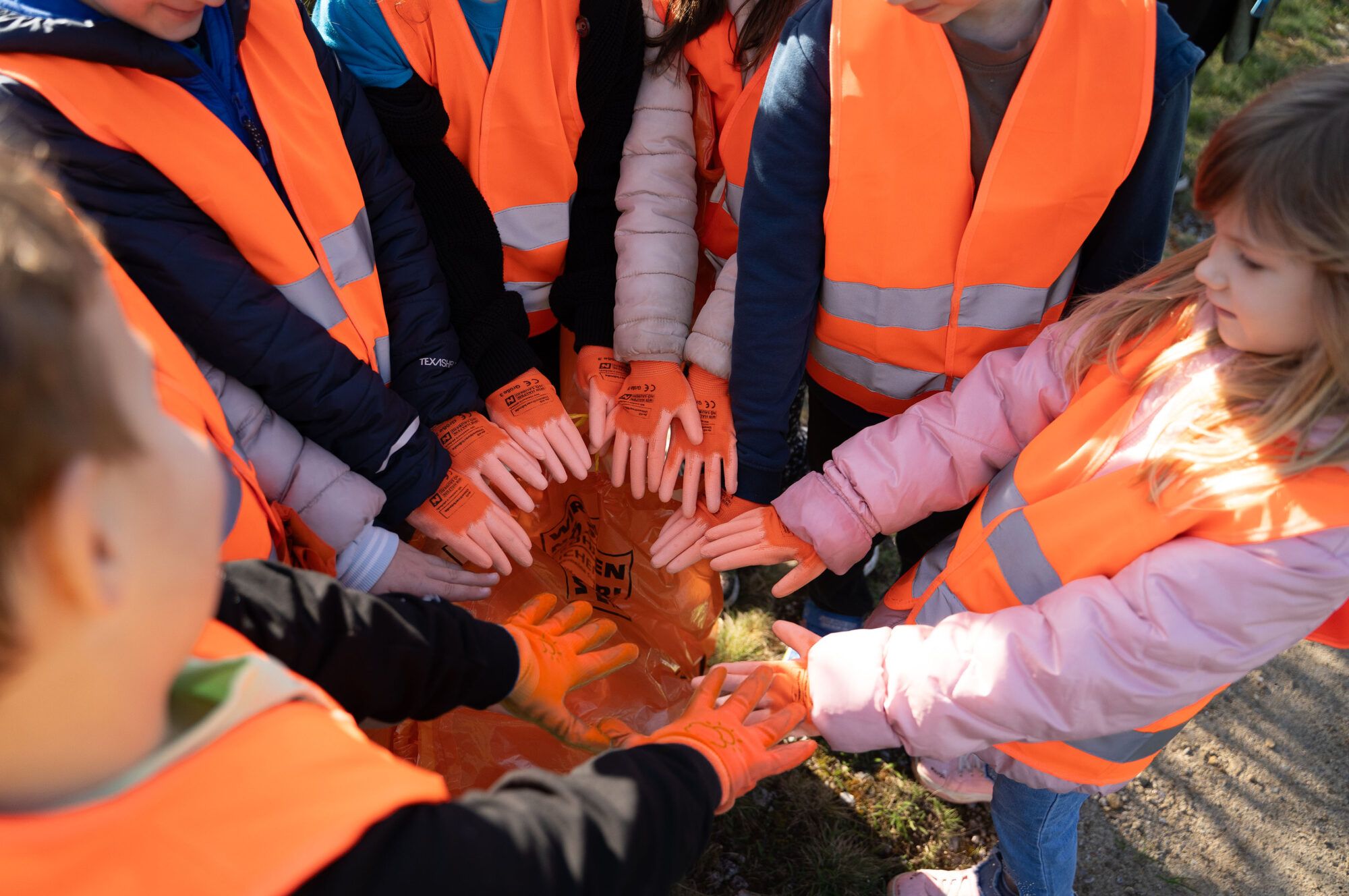 Kinder halten ihre H&auml;nde wie bei einem Teamzusammenkommen in die Mitte
